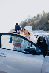 Mother with her little son by the car