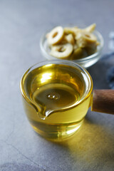  olive oil and fresh olive in a container on table .