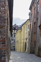 Klimatyczna uliczka na Starym Mieście w Lublinie. Stare i nowe kamienice. Wisząca latarnia na ścianie