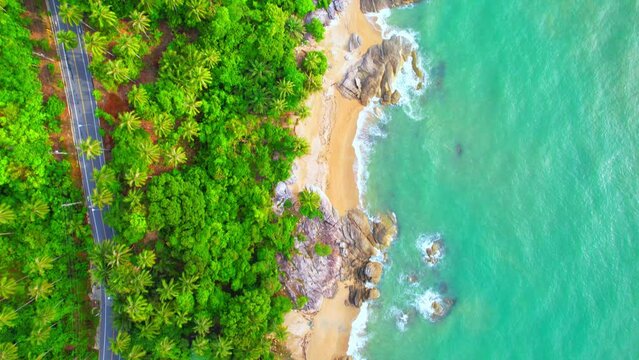 Drones fly over the shores of tropical seas. Many coconut trees. The road parallels the beautiful coast. Turquoise water in the Gulf of Thailand. Khanom-Sichon road. Nakhon Si Thammarat, Thailand. 4K 