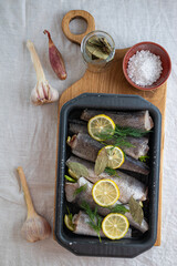 fish hake with lemons and dill marinated and prepared for baking.