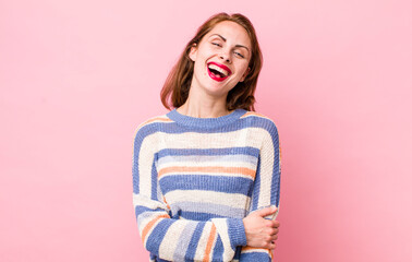 young pretty woman laughing shyly and cheerfully, with a friendly and positive but insecure attitude