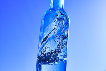 ブルーバックのボトルに入った液体と気泡