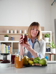 Female nutritionist holding honey in office studio