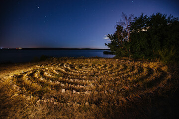 Spiral labyrinth made of stones on the coast, aerial view