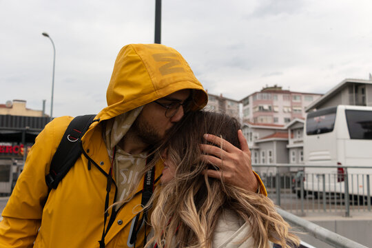 Young couple at street. Man holding womans head and kissing her. Love, romance and relationship concept.