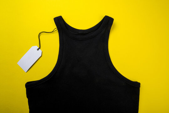 price tag hang over black t-shirt on  yellow background - Image