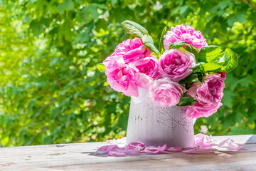 Pink roses in a white vase on a sunny spring day.Bulgarian Damascena Rose.Space for text