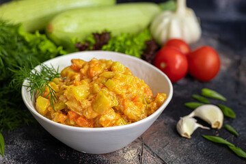 Caviar from zucchini, carrots and onions. Spring food. Vegetarianism. Along with spring vegetables. On a dark background.