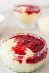 Homemade vanilla pudding with white chocolate and raspberry sauce