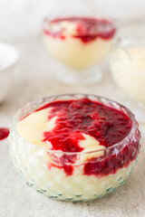 Homemade vanilla pudding with white chocolate and raspberry sauce