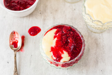 Homemade vanilla pudding with white chocolate and raspberry sauce