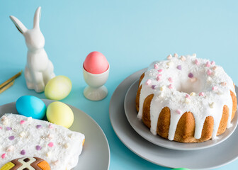 Delicious Easter cakes and eggs, Easter bunny on blue background. Minimal concept.