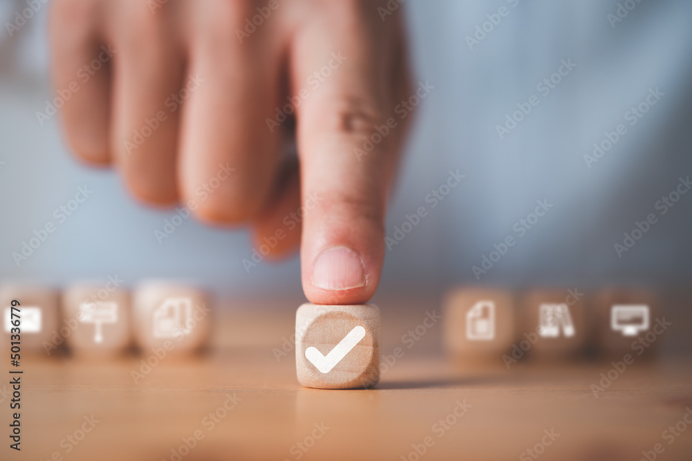 Poster Businessman hand pushing wooden cube block which print screen correct or tick mark for approve document and project concept.