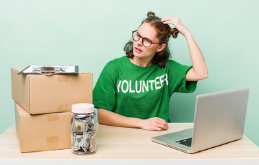 young pretty woman  smiling happily and daydreaming or doubting. donation volunteer concept