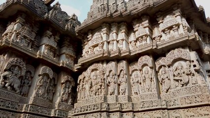 Beautiful carvings of Mythological Gods and Goddesses in stone on the exterior walls of an Old Shiva temple named Lakshmi Narayana at Hosaholalu in Karnataka, India.