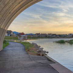 Fototapeta premium Square Whispy white clouds Under an arched bridge over Oquirrh Lake at Daybreak, Utah