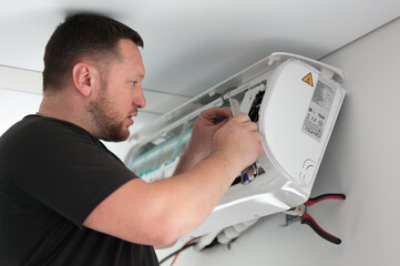 Obraz premium the worker connecting a new air conditioner unit