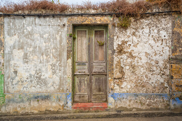 Small weathered house with wooden door