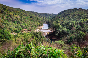 green forests with river flowing and bright blue sky at morning from flat angle