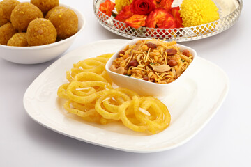 Jelebi famous Indian sweet (tradtional Indian fried sweet dessert) & Chivda or bujiya or namkin & bundi laddu with flowers in a basket