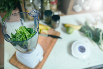 Green smoothie with blender in home kitchen