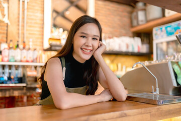 Happiness cheerful Asian female woman in uniform small business coffeeshop asia woman owner working in coffeeshop,chinese female barista making coffee with coffee machine at the cafe shop store