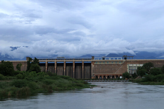 A water reservoir surrounded by the beauty of the clouds, mountains, and trees 