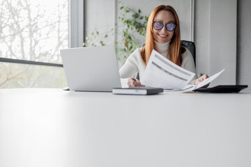 Happy mid aged business woman working with papers.