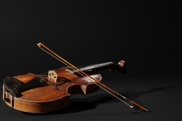 Rustic violin on black background. Musical instrument template. Vintage violin with copy space.