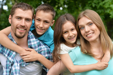 Portrait of happy young family in summer  park