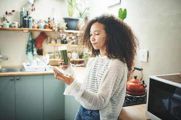 Girl browsing on social media while enjoying her green smoothie