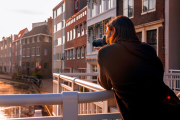 Single male visitor taking photos in the evening sunlight in Schiedam, the Netherlands