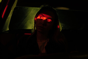 girl sits on the back seat in the car, dark road