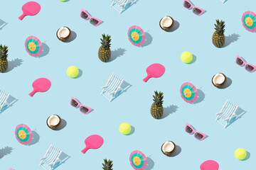 Summer pattern with pineapple, coconut, sunglasses, cocktail umbrella, tennis ball, racket, and beach chair on blue background. - Powered by Adobe