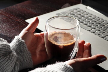 Coffee cup and Businesswoman working with laptop at home . Selective focus