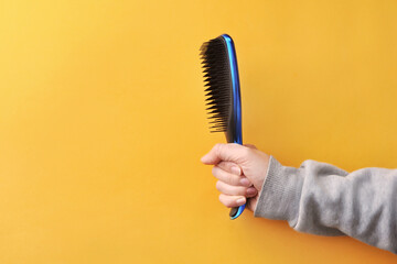 A blue comb in the hands of a woman