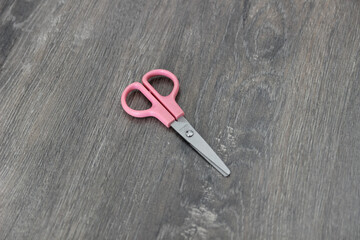 scissors on the wooden floor. Top view, flat lay composition