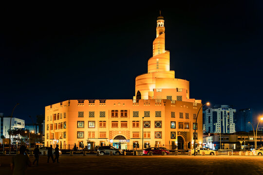 Doha, Qatar - Apr. 2020: Historical building of the mosque with a spiral staircase. Night view of downtown Doha, Qatar. The building is illuminated with golden soft light.