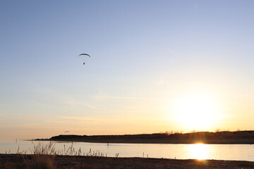 Einsamer Paragleiter fliegt in den Sonnenuntergang