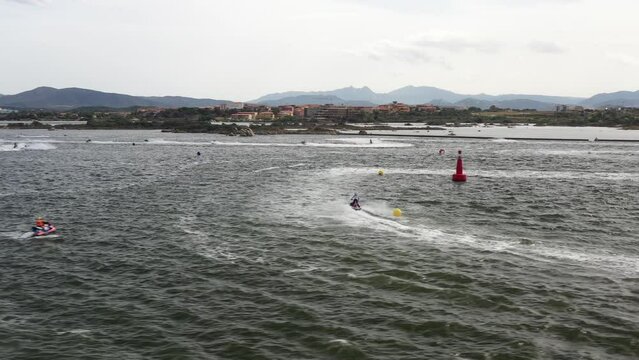 drone image panning over the sea water full of blazing fast jet ski while training for the world cup