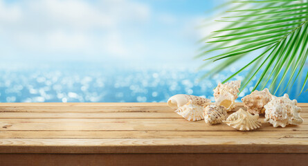 Empty wooden table with seashells over sea beach background.  Summer mock up for design and product...