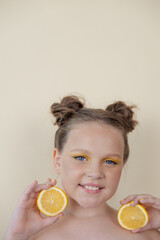 charming tween girl with slices of ripe lemon on yellow background. juicy fruit concept. summer