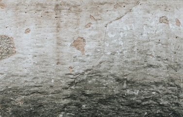 A weathered wall background in shades of grey, beige and white. A plaster old wall with grunge texture.