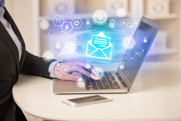 Hands working on laptop with digital icons