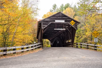 Tuinposter Old wooden covered bridge in the countryside of New Hampshire, USA, on a cloudy autumn day. Fall foliage. © alpegor