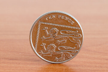 UK ten pence coin on wooden table.