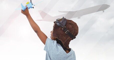 Animation of happy african american boy playing with plane toy over silhouette of plane