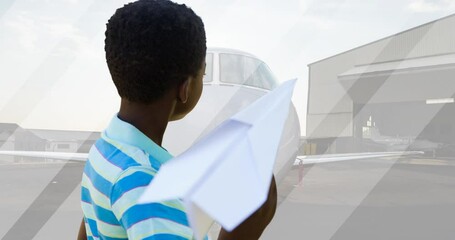 Animation of happy african american boy playing with paper plane over plane