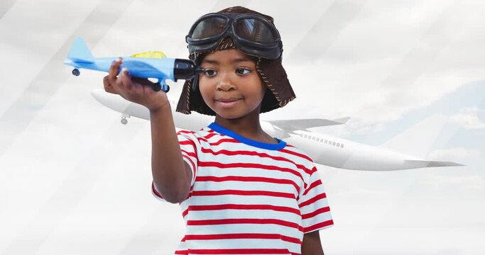 Animation of happy african american boy playing with plane toy over silhouette of plane - Powered by Adobe